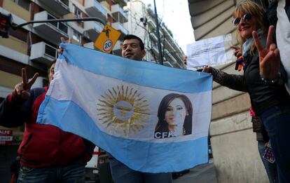 Partidarios de la presidenta argentina, Cristina Fernández Kirchner, sujetan una bandera con su imagen frente a su casa mientras espera que abandone los juzgados en Buenos Aires (Argentina). 