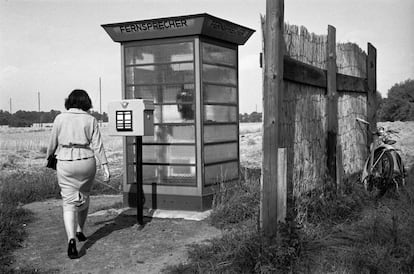 Una mujer se acerca a una cabina de teléfono, situada cerca del límite entre el Oeste y el Este de Berlín, antes de la construcción del Muro. Los berlineses del Este recurrían a menudo a ese teléfono para comunicarse con amigos, familiares y conocidos de la zona occidental.
