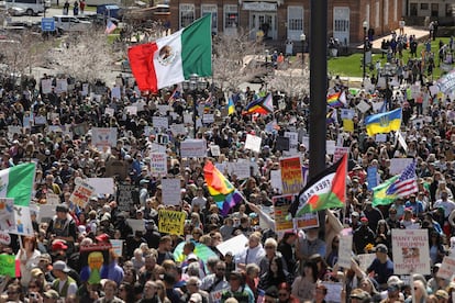 Los manifestantes sostienen carteles y banderas durante una manifestación en Salt Lake City, Utah.