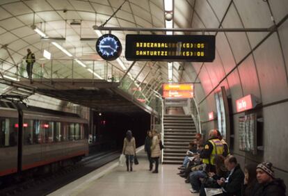 Varios viajeros esperan el metro, que circula con normalidad esta mañana, en la estación del Casco Viejo en Bilbao.