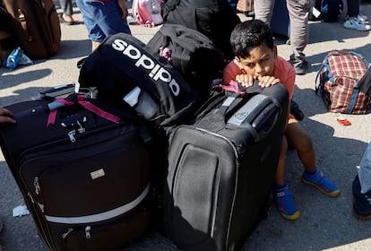 Un niño aguardaba sentado junto a las maletas de su familia para cruzar a Egipto a través del paso de Rafah (Gaza), el lunes.