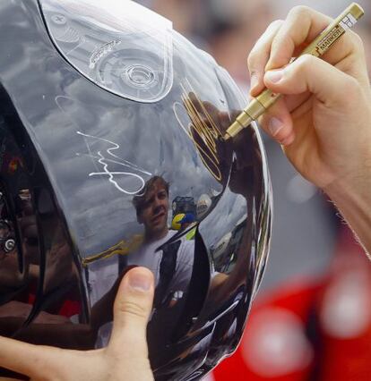 El piloto alemán de Fórmula Uno Sebastian Vettel firma autógrafos antes del primer Gran Premio de la temporada.