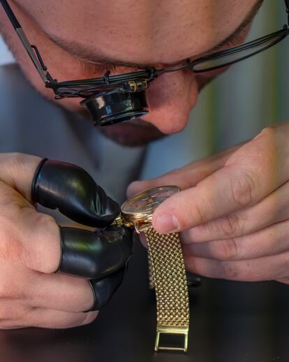 An expert examines a watch during the auction.