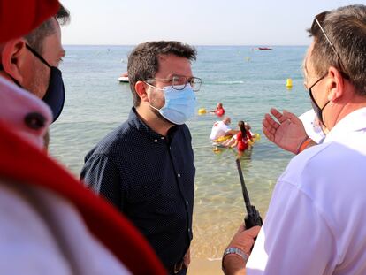 El presidente de la Generalitat, Pere Aragonès (en el centro), durante su visita al servicio preventivo de socorrismo en la playa de Caldes d'Estrac (Barcelona), este viernes
