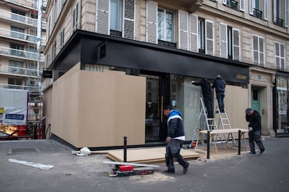Unos trabajadores tapan con maderas los escaparates de una tienda en el Boulevard Beaumarchais, antes de la protesta planificada, en París, este jueves 19 de enero.
