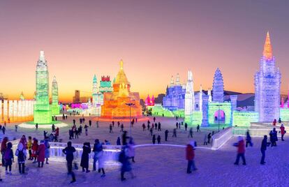 Los visitantes del Festival de esculturas de hielo y nieve de Harbin (China) pasean por sus instalaciones, el 23 de diciembre de 2018.