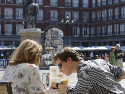 Dos turistas en la plaza Mayor.