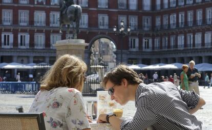 Dos turistas en la plaza Mayor.