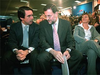 Aznar, con Rajoy, durante la convención del PP. Al lado del candidato, su mujer, Elvira Fernández.