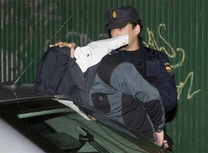 Un policía traslada a uno de los detenidos esta madrugada en Vitoria.