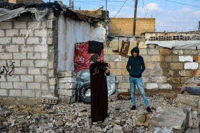 Alia Hasan, de 52 años, con su hijo Faruk, junto a las ruinas de su casa.
