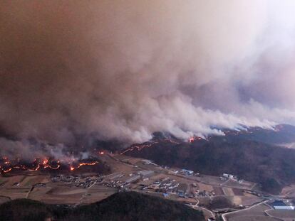Una enorme humareda se extiende por encima de varias líneas de fuego en Andong (Corea del Sur), este martes.