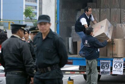 Varias personas trasladan las papeletas a un centrol electoral de la ciudad de Lima.