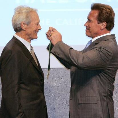 Schwarzenegger pone la medalla a Eastwood cuando ingresó en el Paseo de la Fama de California, en 2006.