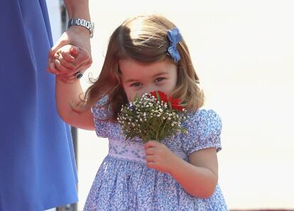 La princesa Carlota, de 2 años, huele sonriente un ramo de flores que le han regalado, al igual que a su madre, a su llegada a Berlín, en la que es su segunda gira oficial por el extranjero.