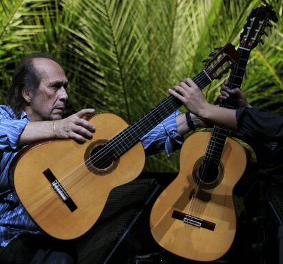 Antonio Sánchez cambia la guitarra a Paco de Lucía durante un concierto en la Bienal de Flamenco en Sevilla, octubre de 2010.