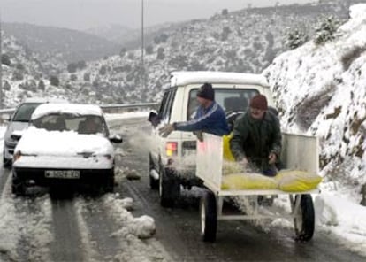 Dos trabajadores echan sal en Pedrezuela (Madrid).