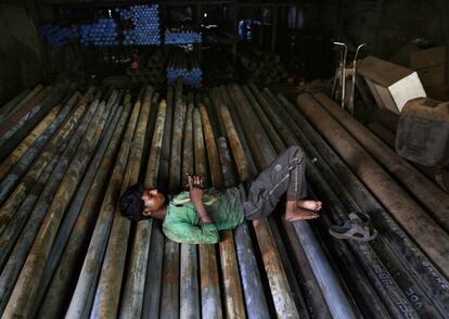 Un trabajador indio descansa durante una pausa para el almuerzo en una factoría dedicada a la forja de hierro y acero en Bombay, India. 3 de junio de 2014.