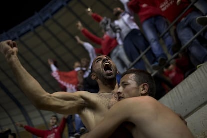 Bnei Sakhnin soccer supporters celebrate a goal against Beitar Jerusalem FC at the Teddy Stadium in Jerusalem, Sunday, Feb. 10, 2013. Hundreds of police deployed around Beitar Jerusalem's stadium, two days after a suspicious fire believed to be set by angry fans destroyed the team's main offices. Tensions remained high Sunday as the team faced off with Bnei Sakhnin, an Arab team whose fans have clashed before with Beitar's. (AP Photo/Bernat Armangue)