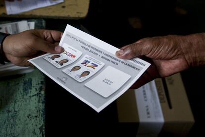 Un ciudadano colombiano recibe una lista para votar en las presidenciales.