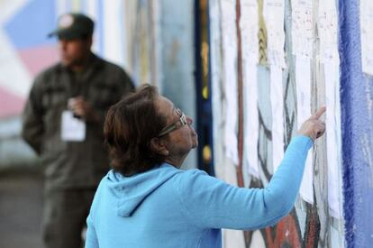 Una mujer busca su mesa de votación para participar en las elecciones.