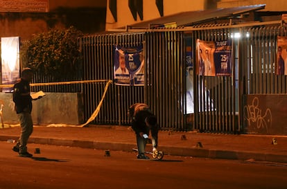 Investigadores de la policía caminan sobre la escena a las afueras del colegio en donde el candidato presidencial Fernando Villavicencio fue asesinado.