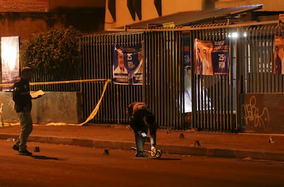 Investigadores de la policía caminan sobre la escena del crimen a las afueras del colegio en donde el candidato presidencial Fernando Villavicencio fue asesinado.