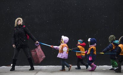 Un maestro de escuela intenta atrapar los copos de nieve mientras dirigía a sus alumnos a una biblioteca en una escuela, en el barrio de Harlem en Nueva York (EE UU).