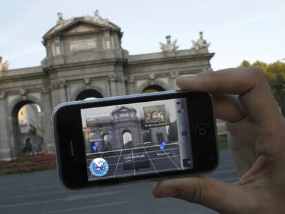 Un turista utiliza su iPhone para situarse en la plaza de la Independencia de Madrid.