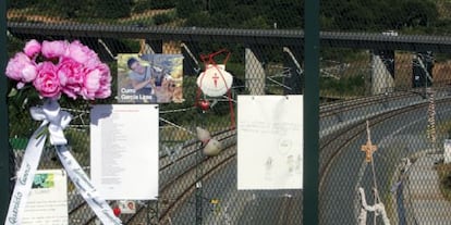 People leave flowers, messages and photos in memory of the train crash victims at the bridge over A Grandeira curve, in Angrois.