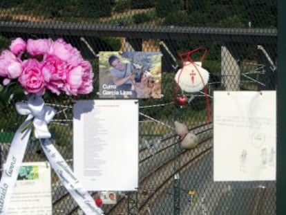 People leave flowers, messages and photos in memory of the train crash victims at the bridge over A Grandeira curve, in Angrois.