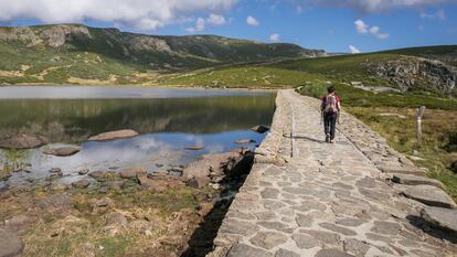 Una mujer camina cruzando la presa de la Laguna de los Peces en Sanabria, Zamora, España.