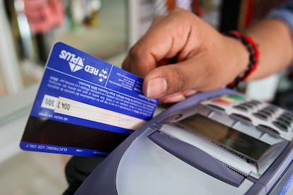 Una tarjeta de crédito deslizada por una terminal bancaria