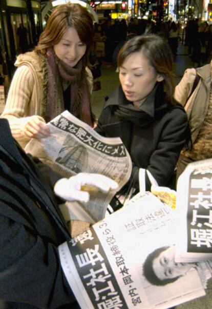 Ciudadanos japoneses leen una edición especial de los periódicos con la detención de Takafumi Horie