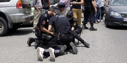 Varios policías reducen a una persona ante la sede de Correos de Melilla, tras el altercado entre simpatizantes del PP y CPM.