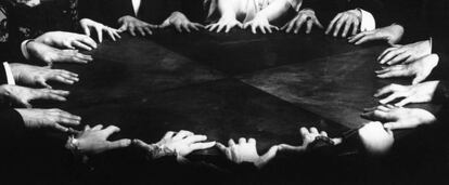 Les mans, pendents del dictat dels esperits en una sessió d'ouija.
