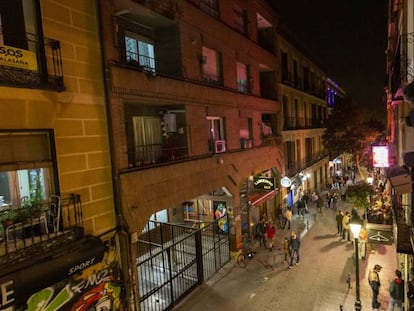 Vecinos de Malasaña contemplan desde un balcón el bullicio en la calle Velarde. 
 