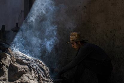 Un operario del palenque mezcalero Macurichos, en plena faena de horneado de pencas.