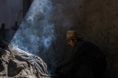 Un operario del palenque mezcalero Macurichos, en plena faena de horneado de pencas.