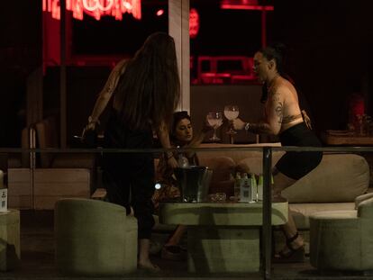 Tres chicas bailan y beben en la discoteca Pacha junto a la playa del Somorrostro.