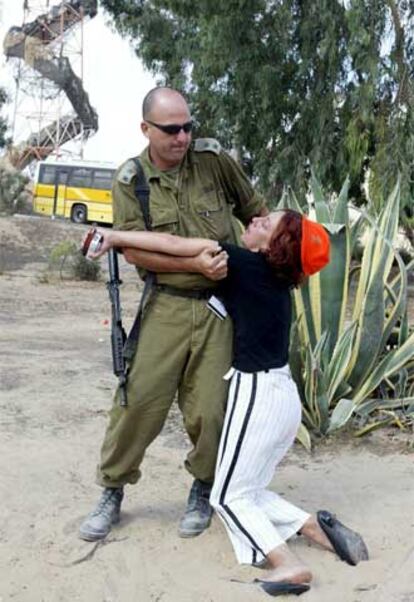 Un militar israelí ayuda en Gush Katif a una mujer que se ha desmayado.