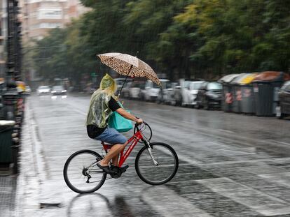 Un hombre circula en bicicleta bajo la lluvia, el domingo pasado en la ciudad de Valencia.