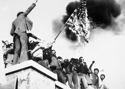 Un grupo de manifestantes quema una bandera de EEUU. Están subidos sobre el muro que rodea la embajada de ese país en Teherán, tomada pocos días antes por un grupo de "estudiantes revolucionarios". Desde aquella fecha, la quema de enseñas norteamericanas se ha convertido en un ritual para expresar el rechazo de la República Islámica al imperialismo y la intromisión extranjera en sus asuntos. Con el paso de los años, es un gesto que se asocia sobre todo con los ultraconservadores. Entre la juventud educada y urbana el antiamerianismo era marginal hasta la llegada de Trump y su política de presión a Irán.