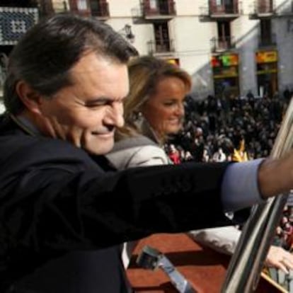 El nuevo presidente catalán, Artur Mas, junto a su esposa, Helena Rakosnik, saludando desde el balcón del Palacio de la Generalitat tras tomar posesión del cargo hoy en Barcelona.