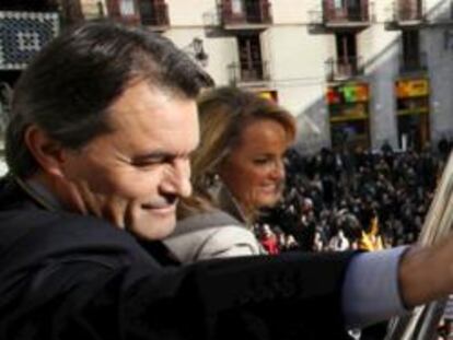 El nuevo presidente catalán, Artur Mas, junto a su esposa, Helena Rakosnik, saludando desde el balcón del Palacio de la Generalitat tras tomar posesión del cargo hoy en Barcelona.