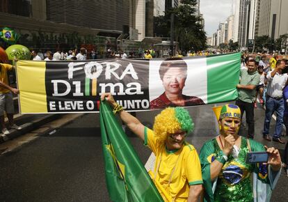 Manifestantes delante de un cartel con el lema 'Fuera Dilma'.