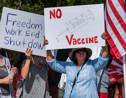 Um grupo contrário às medidas de confinamento se manifesta na Califórnia com um cartaz crítico às vacinas.