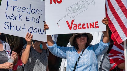Um grupo contrário às medidas de confinamento se manifesta na Califórnia com um cartaz crítico às vacinas.