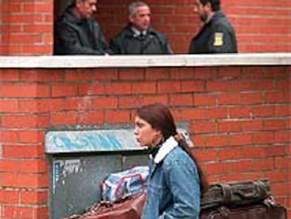 Una joven se sienta en una maleta tras ser desalojada del edificio de Usera.