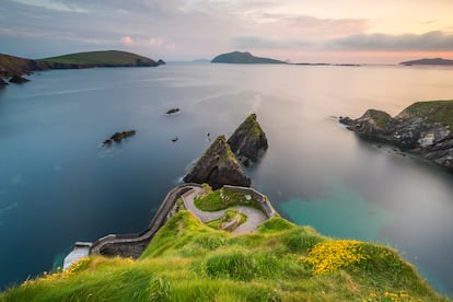 Wild Atlantic Way (Irlanda). El extremo occidental de Irlanda tiene uno de los litorales más asombrosos del mundo: 2.500 kilómetros de abruptos acantilados y playas en forma de medialuna entre el oeste de Cork y el noreste de Donegal. La ruta tiene cinco tramos conectados entre sí, que abarcan nueve condados: Cork, Kerry, Clare, Limerick, Galway, Mayo, Sligo, Leitrim y Donegal. Está muy bien señalizada con casi 4.000 carteles y con la indicación de los puntos en los que detenerse. Las penínsulas más conocidas y visitadas del país están en Cork y Kerry, con lugares como Dunquin pier (en la foto) o el faro de Fasnet, colgado sobre una roca conocida como “la lágrima de Irlanda” porque era lo último que veían los emigrantes que partían hacia América durante la Gran Hambruna. En el Condado de Clare están los acantilados de Moher, los más famosos de Irlanda, un paisaje de caliza y bellas playas de surf.  Mayo y Sligo son menos conocidos, pero tienen también paisajes sorprendentes y desolados, hermosas islas y varias playas que están entre las favoritas de los surfistas.  